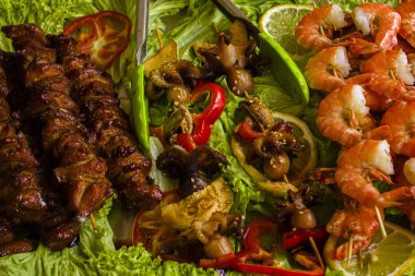 marul yaprakları üzerinde ızgara deniz ürünleri