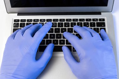 Kişisel güvenlik araçlarını kullanarak bir bilgisayarda çalışıyoruz. Maske, eldiven.