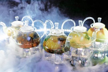 Bir sürü cam çaydanlık ve bir kafedeki dumanın üstünde çay.