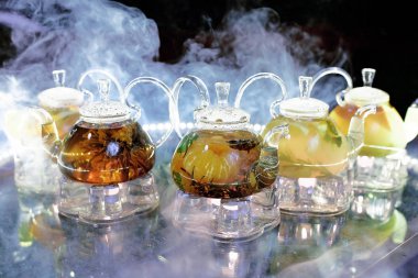 Bir sürü cam çaydanlık ve bir kafedeki dumanın üstünde çay.