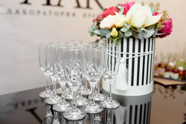 Copas de vino y flores sobre la mesa — Foto de Stock