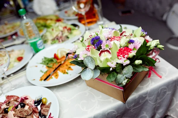 Flores y comida sobre la mesa — Foto de Stock