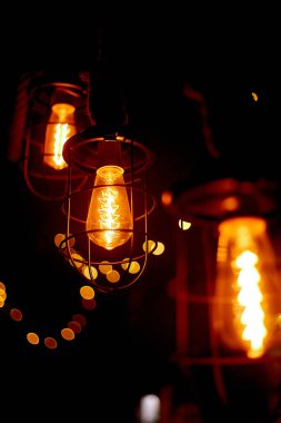 Konforlu, ahşap bir duvardaki bir enstitüde lamba ışığı. Tavanda asılı cam ampuller ve sıcak bir ışık..