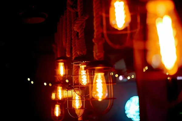 Cozy, lamp lighting in an institution on a wooden wall.Glass bulbs hanging on the ceiling shine and warm light.