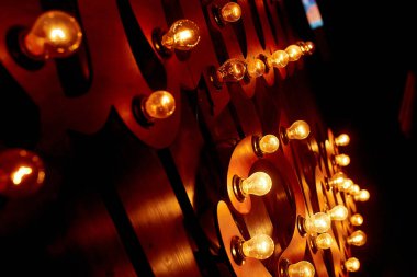 Ahşap duvardaki bir enstitüde konforlu, lamba ışığı. Cam ampuller hoş ve sıcak bir ışıkla parlıyor. 