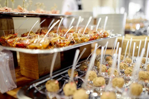 Imbissbuffet, Kanapees auf Tabletts. Snacks mit Fleisch, Obst, Käse mit einem individuellen Löffel für jeden Gast — Stockfoto