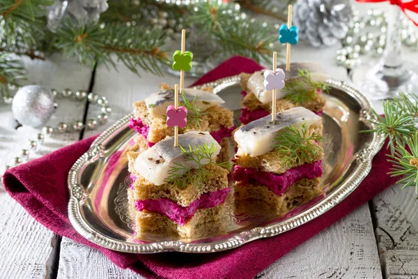Canapes in the form of a star with pickled herring, beetroot and — Stock Photo, Image