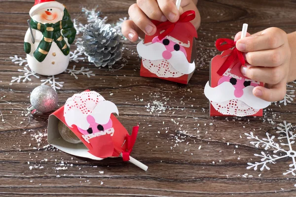 Das Kind erstellt eine Grußverpackung für Süßigkeiten Weihnachtsmann auf p — Stockfoto