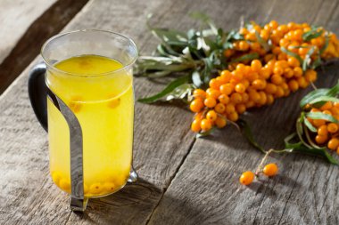 Sonbahar sıcak içeceği. Vinta üzerinde deniz-buckthorn çilek dalı ile Çay