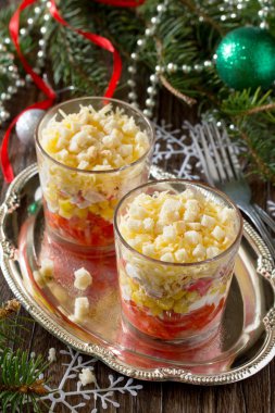 Ahşap bir sekme üzerinde domates, mısır ve kraker ile Noel salatası