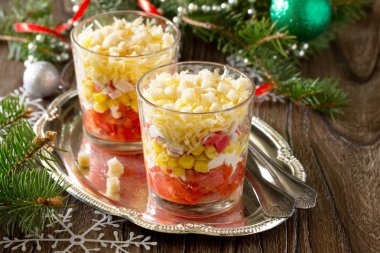 Ahşap bir sekme üzerinde domates, mısır ve kraker ile Noel salatası