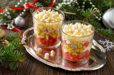 Ahşap bir sekme üzerinde domates, mısır ve kraker ile Noel salatası