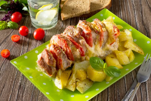 Pieczone mięso z serem i pomidorami z pieczonymi ziemniakami na drewnianym tarasem — Zdjęcie stockowe
