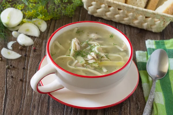 Sopa de frango e macarrão com salsa em um fundo de madeira escura . — Fotografia de Stock