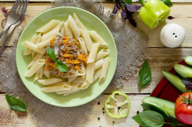 Rustik bir st tabloda bir tavada kıyılmış etli makarna