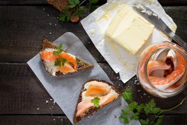 Salted salmon fillets with sea salt on rye bread. Fresh fish. To — Stock Photo, Image