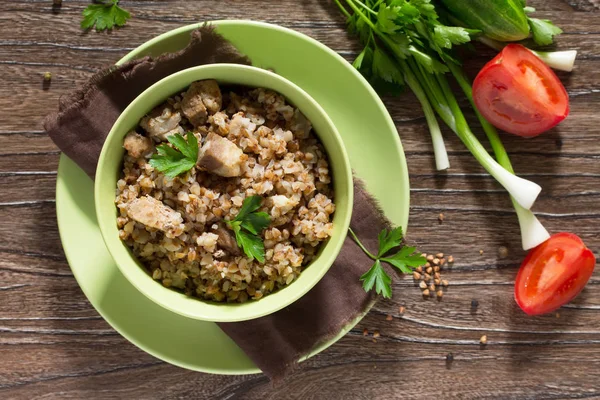 Boekweit met stoofpot van vlees en verse groenten op een houten tafel. — Stockfoto