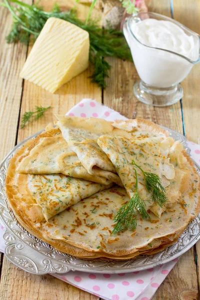 Nicht süße Pfannkuchen mit Käse und frischem Dill auf einem Holztisch. — Stockfoto