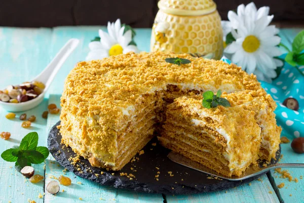 Tarta de miel casera con crema agria en una mesa de madera con pasas —  Fotos de Stock