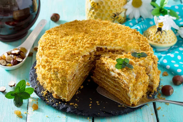 Doce bolo de mel em camadas em casa em uma mesa de madeira com passas e — Fotografia de Stock