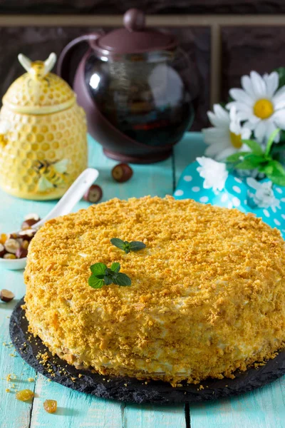 Sweet home layered honey cake on a wooden table with raisins and