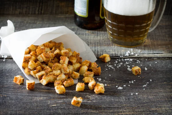Crab croutons in a paper bag on a wooden table. Snack food to be