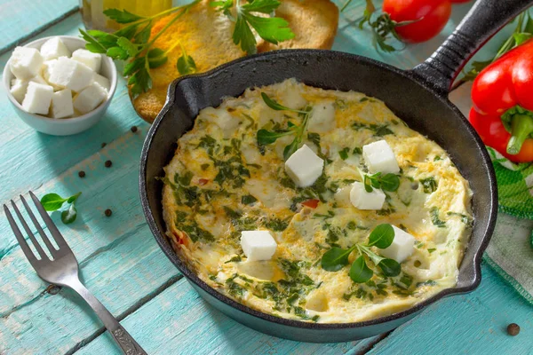 Omelette cu ardei, roșii și brânză feta într-un fontă f — Fotografie, imagine de stoc