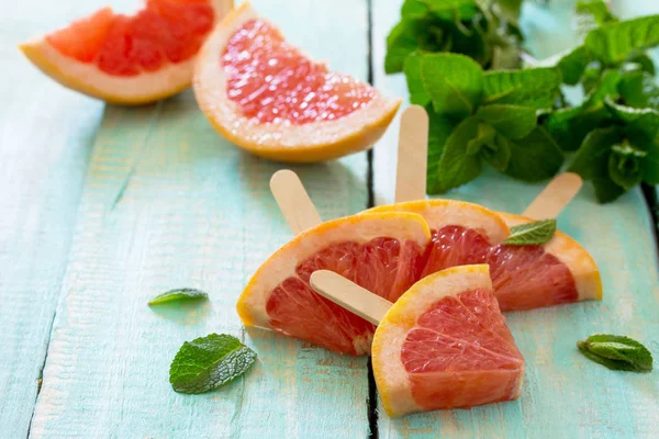 Sommer-Hintergrund. Scheiben rotes Grapefruit-Eis am Stiel auf einem Vintag — Stockfoto