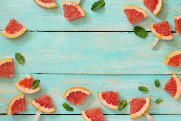 Sommer-Hintergrund. Scheiben rotes Grapefruit-Eis am Stiel auf einem Vintag — Stockfoto