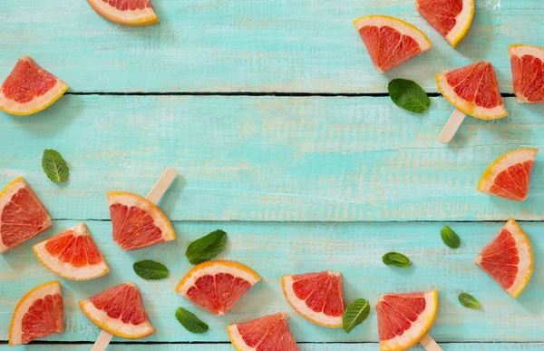 Scheiben rotes Grapefruit Eis am Stiel auf einem Vintage-Holzgrund — Stockfoto
