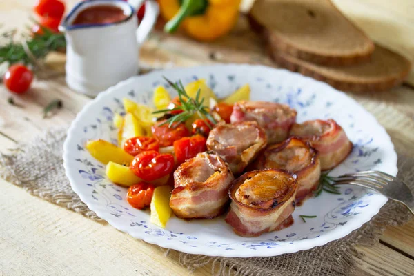 Vepřové medailonky zapečené slaninou a pečené brambory, čerstvá zelenina — Stock fotografie