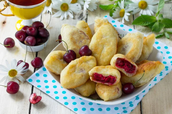 Fried pies. Pies sweet with cherries on the kitchen table in a r