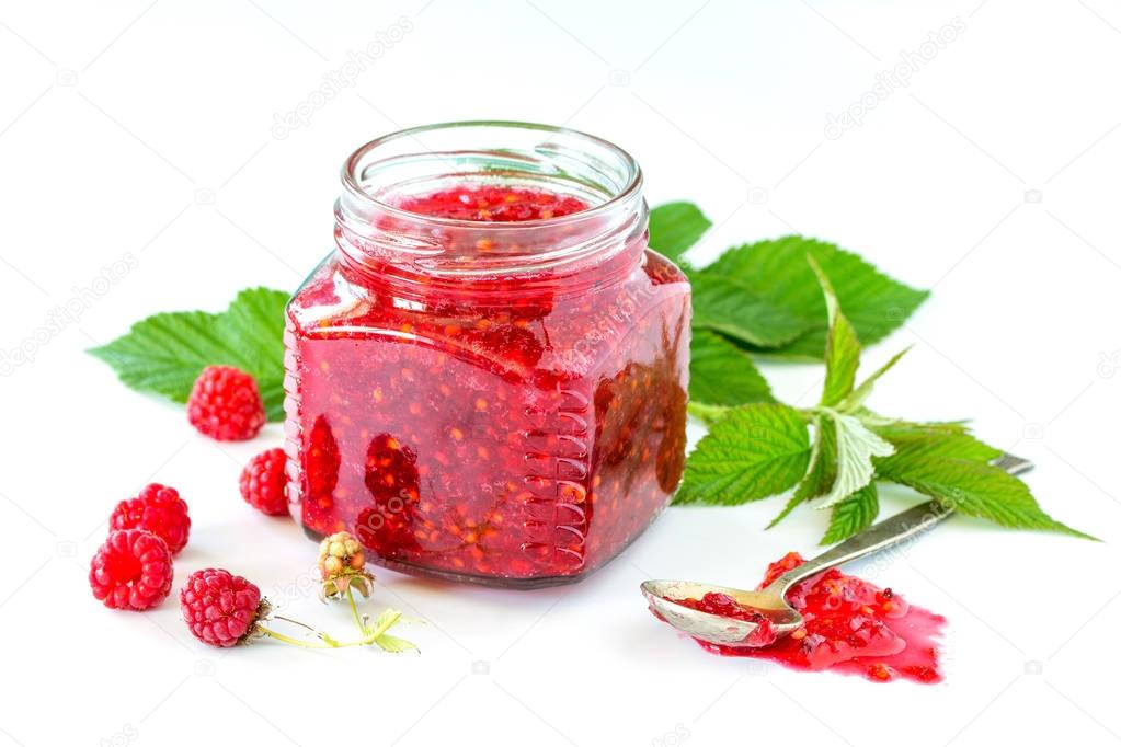 Homemade homemade jam. Glass jar with raspberry jam on a white b