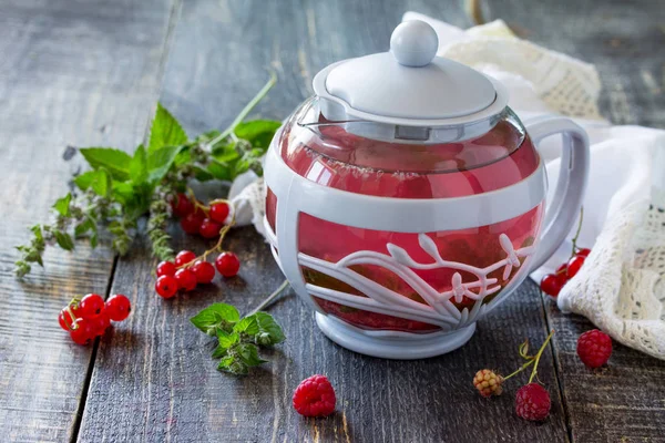 Fruit berry tea with mint, red currant and raspberries on a wood — Stock Photo, Image