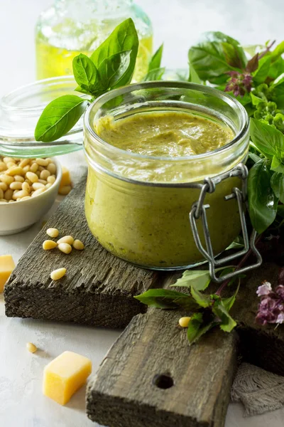 Molho pesto verde, manjericão, parmesão e pinhões em uma pedra ou s — Fotografia de Stock