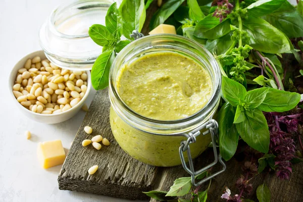 Green pesto sauce, basil, parmesan and pine nuts on a stone or s — Stock Photo, Image