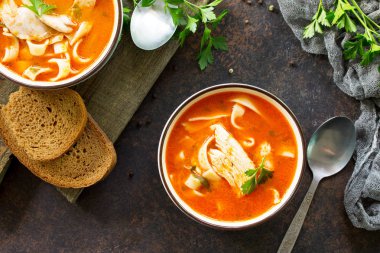 Domates çorbası ile makarna ve tavuk bir karanlık bir kabın içinde TZB taş