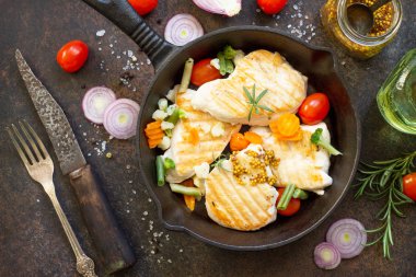 Bir dökme demir fry üzerinde çeşitli sebze ve ızgara tavuk fileto
