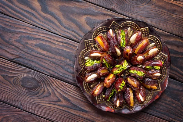 Getrocknete Datteln gefüllt mit kandierten Früchten und Nüssen auf einem rustikalen Woo — Stockfoto