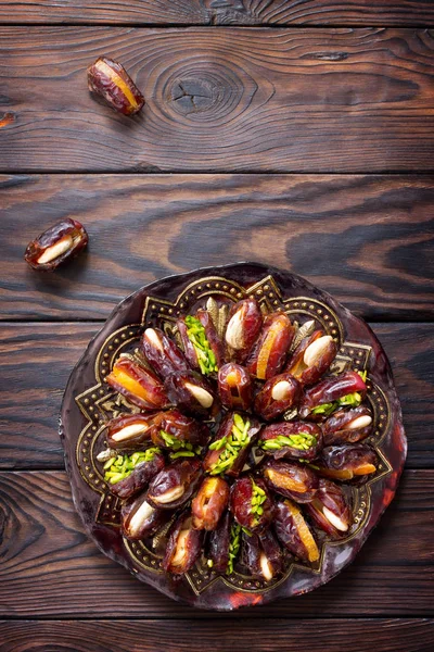 Getrocknete Datteln gefüllt mit kandierten Früchten und Nüssen auf einem rustikalen Woo — Stockfoto