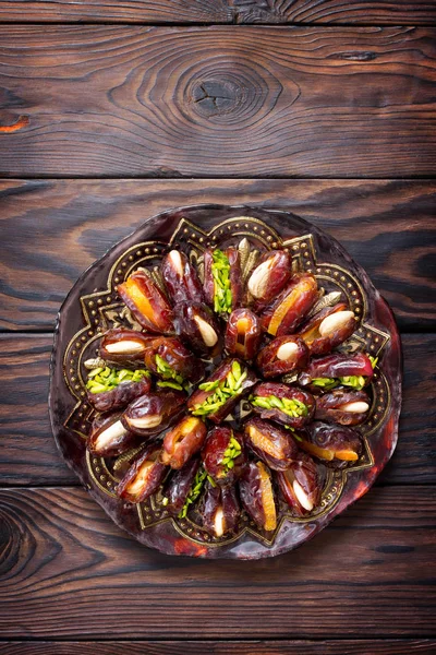 Sušené datle plněné kandovaným ovocem a ořechy na rustikální woo — Stock fotografie