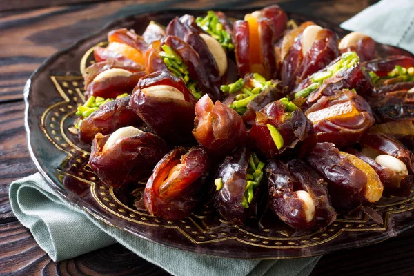 Gedroogde dadels gevuld met gekonfijte vruchten en noten op een rustieke woo — Stockfoto