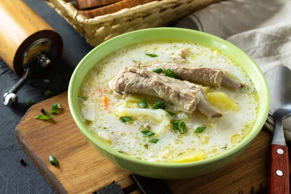 Горячий домашний суп с мясными ребрышками и овощами на каменном счету — стоковое фото