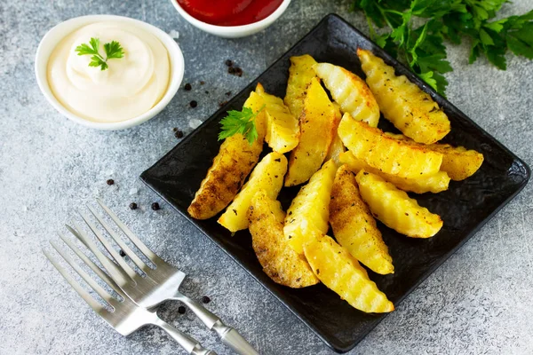 Fast food. Baharatlı fırında patates, levhada veya taşta dilimler.,