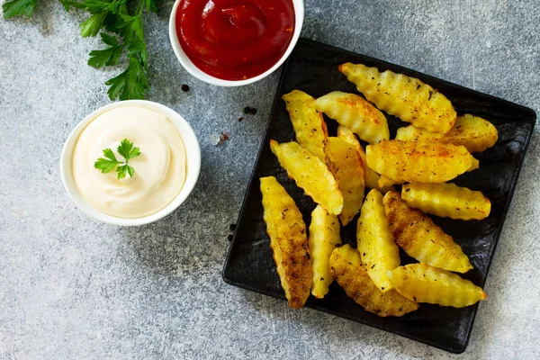 Fast food. Baharatlı fırında patates, levhada veya taşta dilimler.,