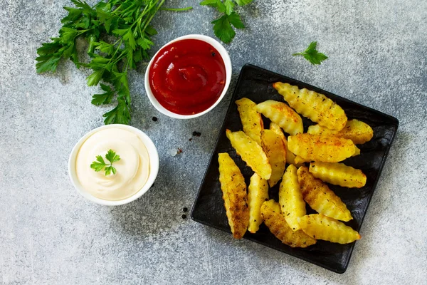 Fast food. Baharatlı fırında patates, levhada veya taşta dilimler.,