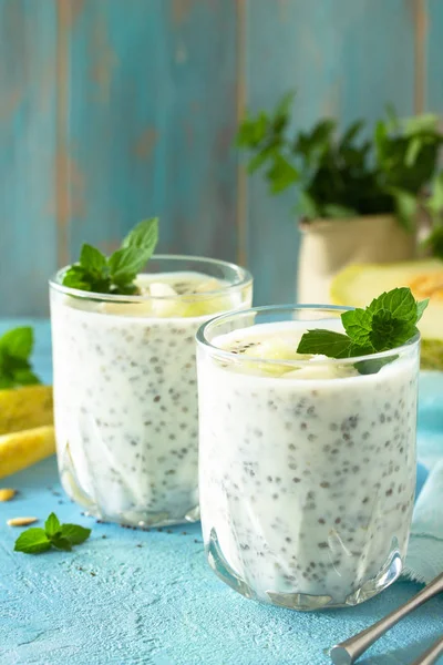 Pudín saludable en un vaso con chía y melón y sobre piedra azul —  Fotos de Stock