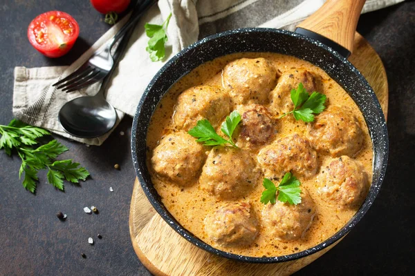 Bakso dalam krim asam dan saus tomat dalam panci di ston gelap — Stok Foto