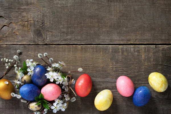 Ostereier in einem Nest mit Weidenzweigen und Frühlingsblumen auf — Stockfoto