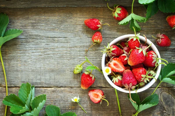 Verse aardbeien in een kom op een houten rustieke tafel. Bovenaanzicht — Stockfoto